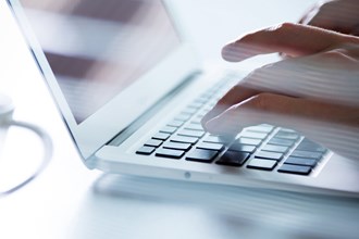 Fingers typing on a laptop keyboard