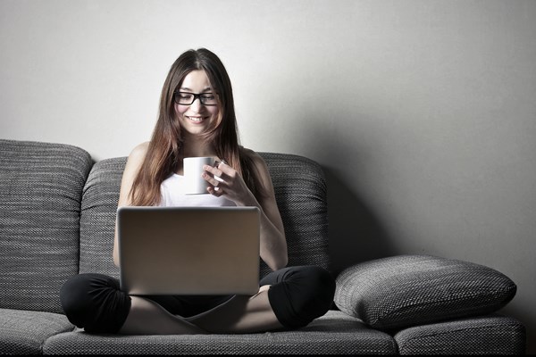 Study online Student working on laptop holding a mug