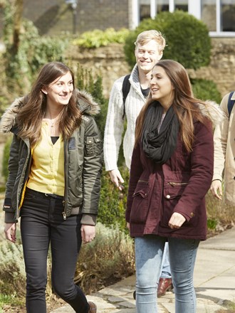 A group of happy students walking through Guildford campus A group of happy students walking through Guildford campus