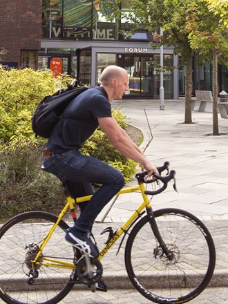 Student cycling outside University of Exeter's campus