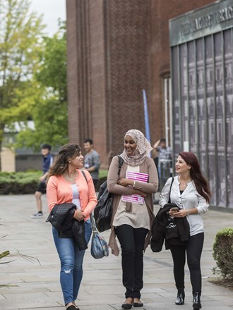 Smiling students walking through Southampton campus