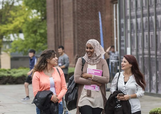 Smiling students walking through Southampton campus