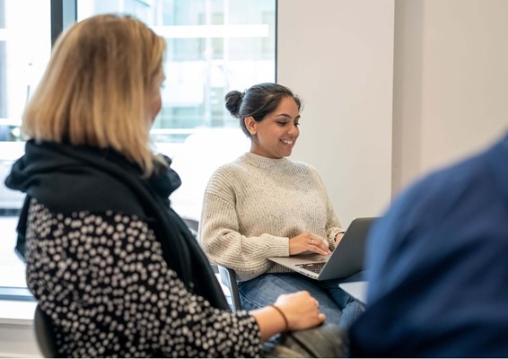 Smiling student in classroom working on her laptop