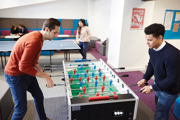two students playing foosball