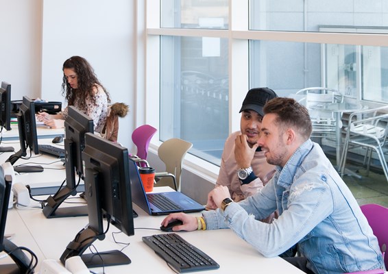 Students talking at a computer