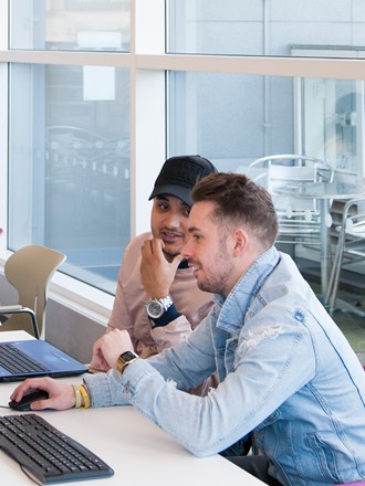 Students talking at a computer