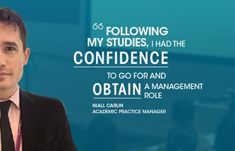 A man in a suit with text overlay about confidence in obtaining a management role, lecture room background.
