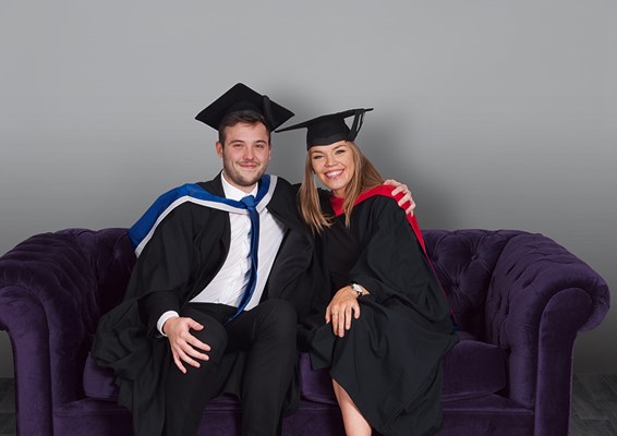 Two University of Law graduates sitting on a sofa