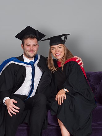 Two University of Law graduates sitting on a sofa