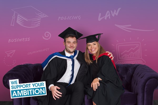 Students in graduation gowns sat on a sofa
