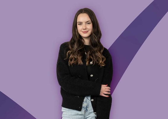 Smiling student on a purple coloured background