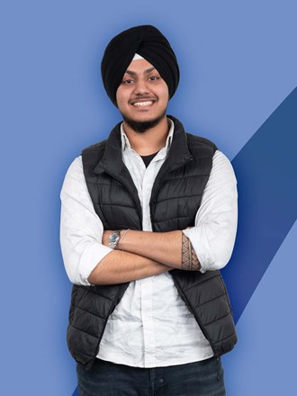 Student with arms crossed and smiling on on a blue coloured background Student with arms crossed and smiling on on a blue coloured background