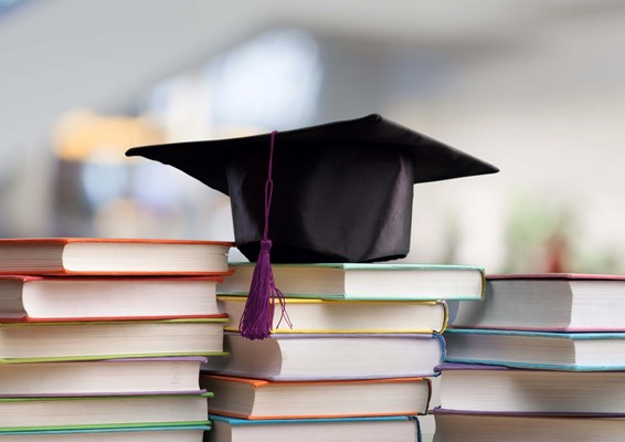 Mortarboard on stack of books Mortarboard on stack of books