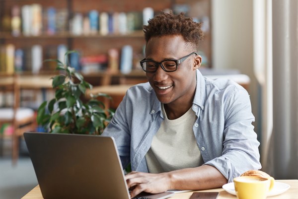 Smiling male student working on a laptop